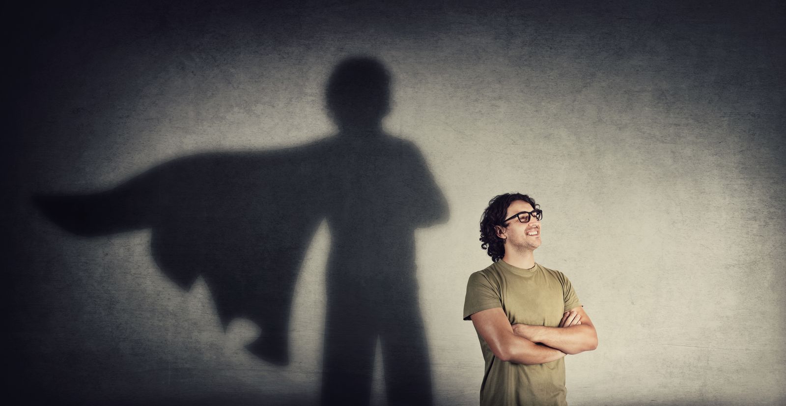 Mann mit Superhelden-Schatten an der Wand