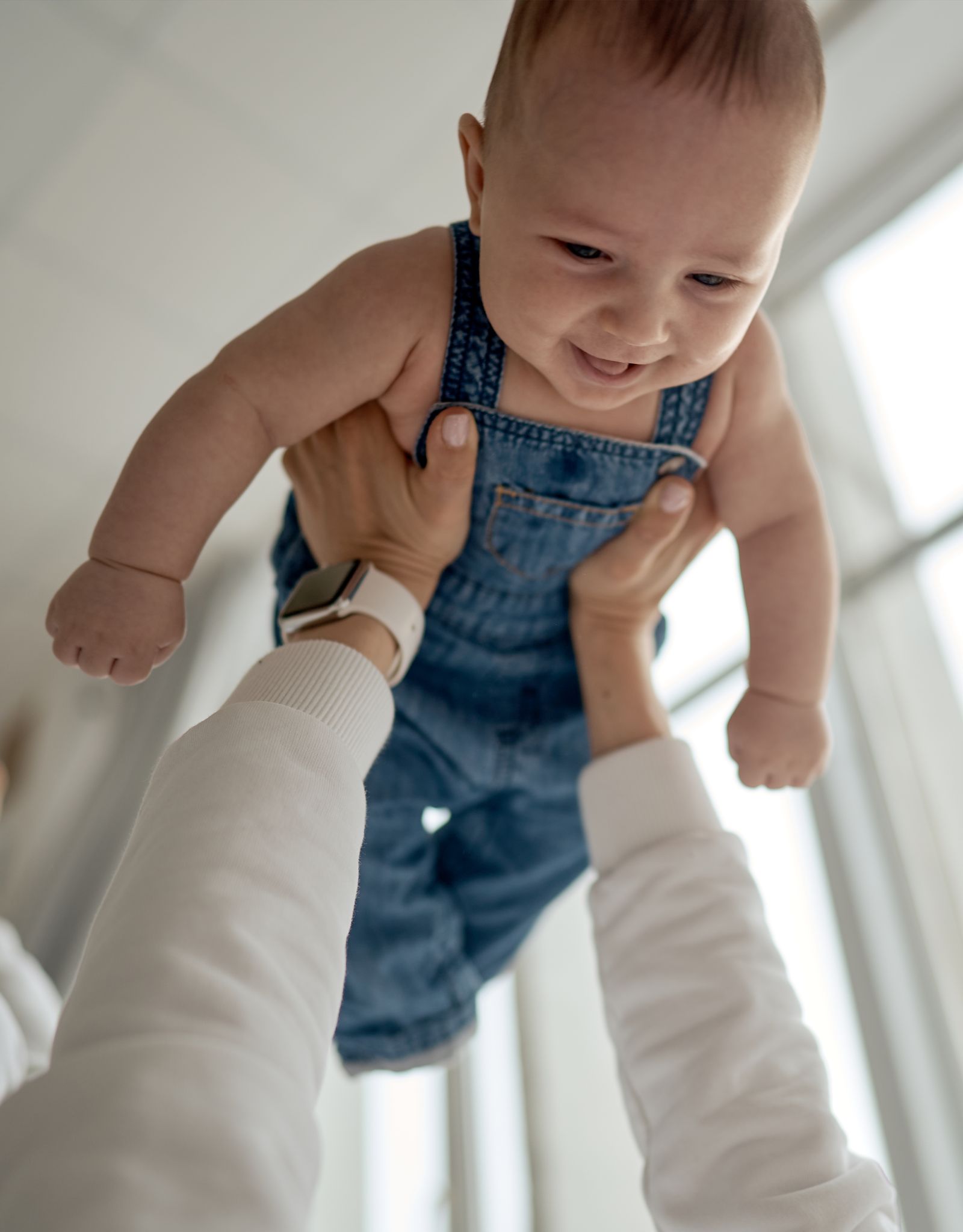 Baby wird lachend in die Höhe gehoben