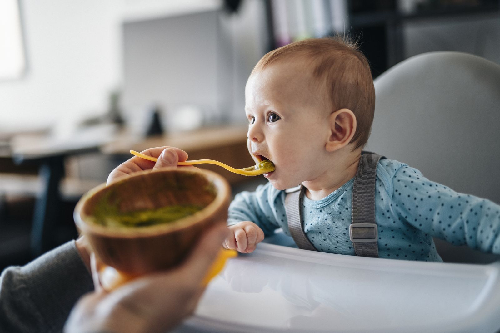 Baby wird im Hochstuhl gefüttert