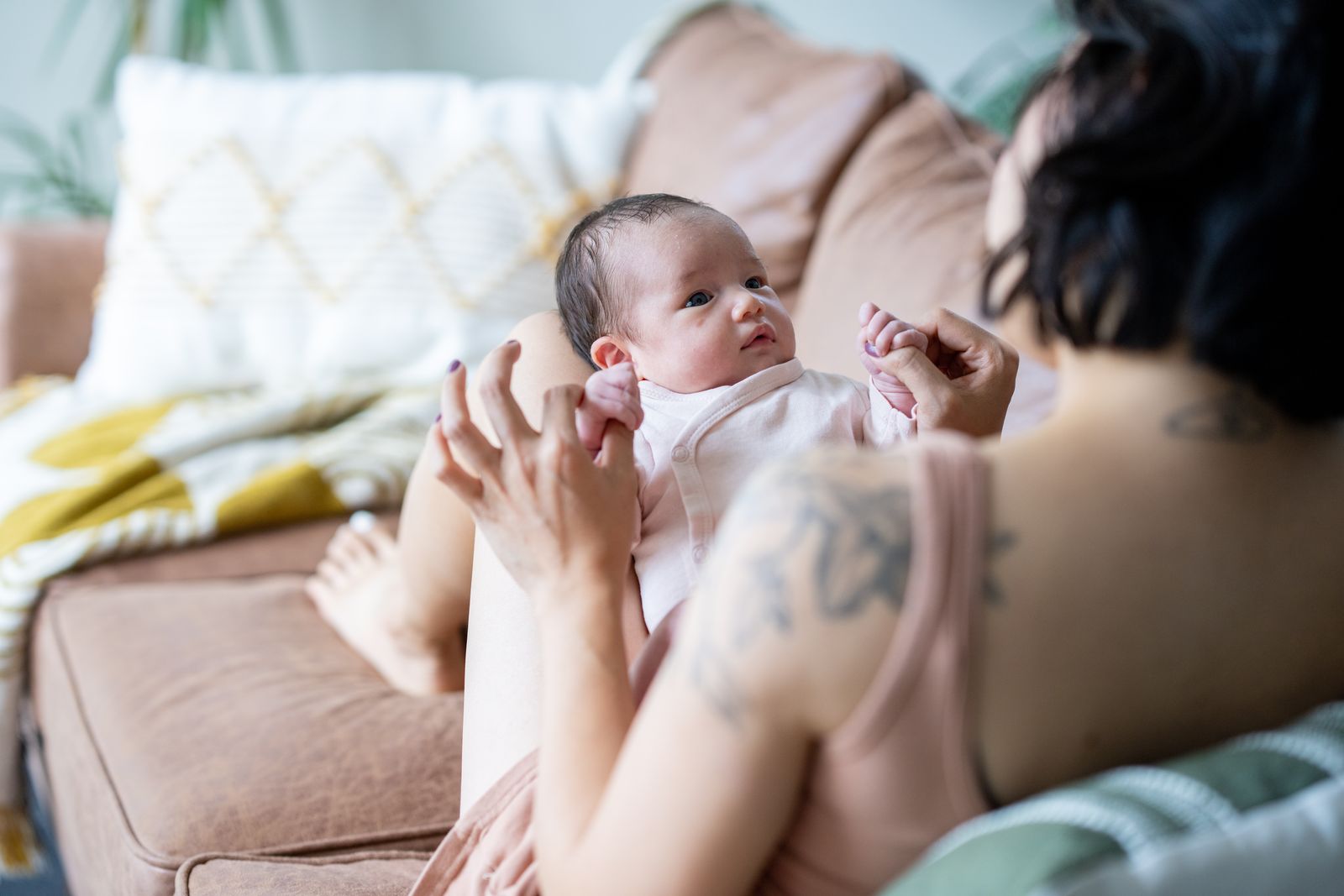Mutter spielt mit ihrem Baby auf dem Sofa